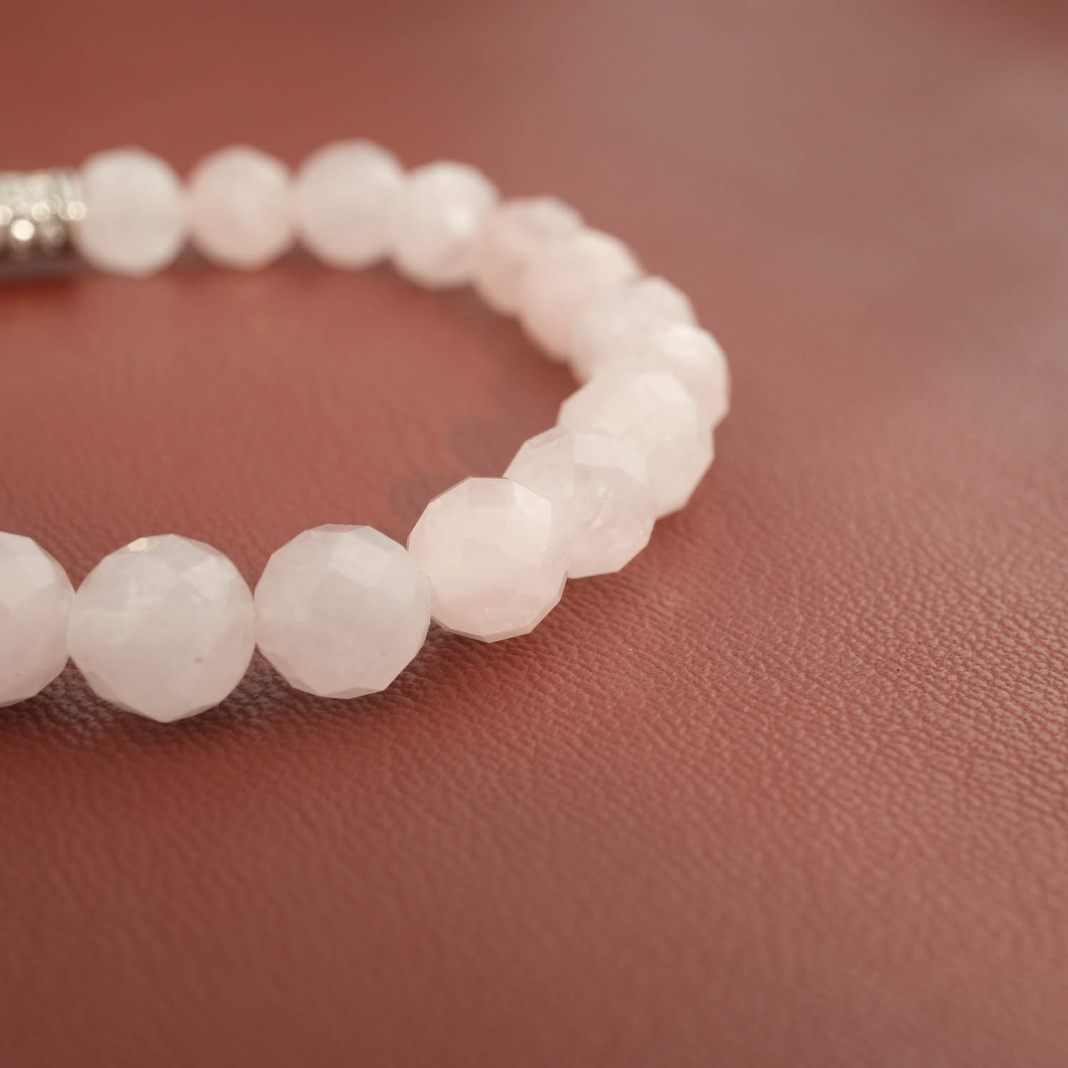 armbaand-natursten-rosakvarts-facetteret-8mm Elegant rose quartz natural stone bracelet made of light-reflecting faceted 8mm beads.