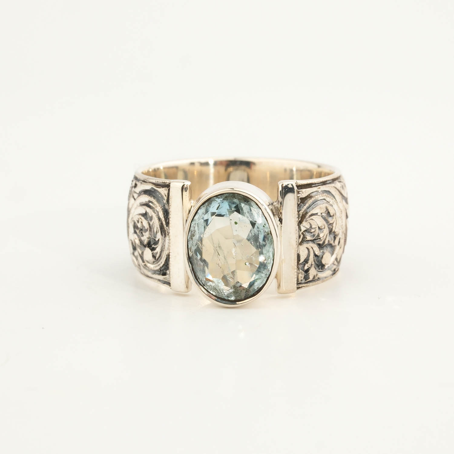 anillo-hombre-plata-hecho-a-mano-aguamarina-ovalada Bague pour homme en argent 925 ornée d'une pierre naturelle d'aigue-marine originale de taille facette ovale et d'un entourage magistralement gravé.