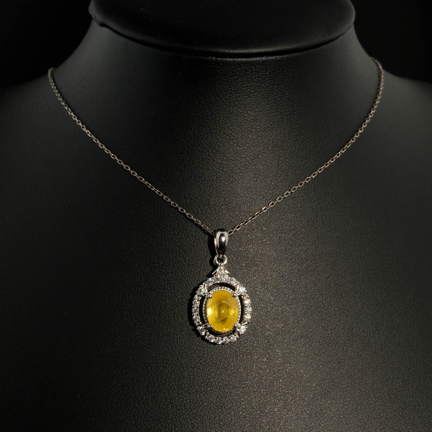 colgante-piedra-natural-zafiro-amarillo-diseno-plata-925 Ciondolo di design di lusso realizzato con una pietra di zaffiro giallo naturale a taglio cabochon ovale incastonata in argento sterling 925 con halo di zirconi.