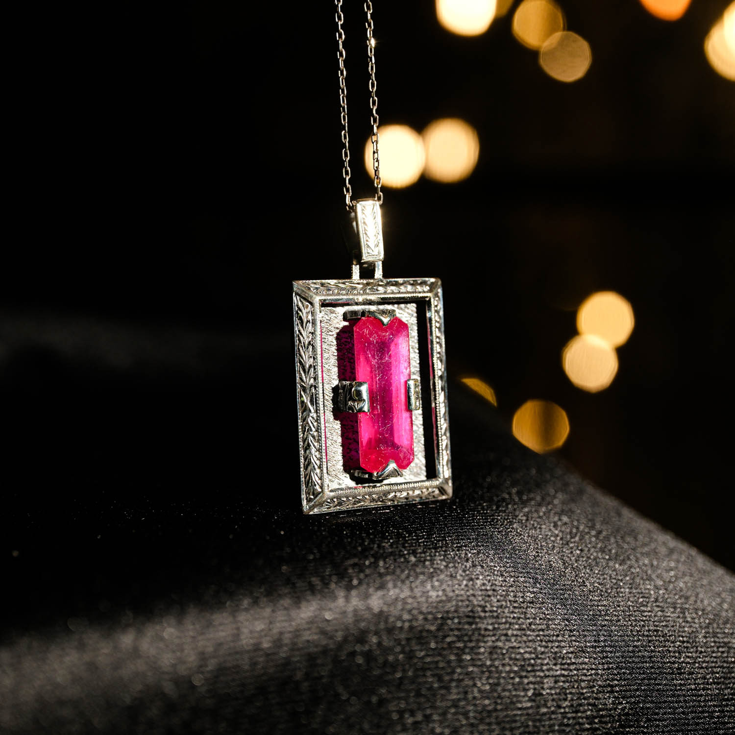 handgefertigte-silberhalskette-rubin-rechteckiges-design Collana in argento 925 con una pietra naturale di rubino originale con taglio a faccette rettangolare in una cornice rettangolare con motivi floreali fatti a mano.