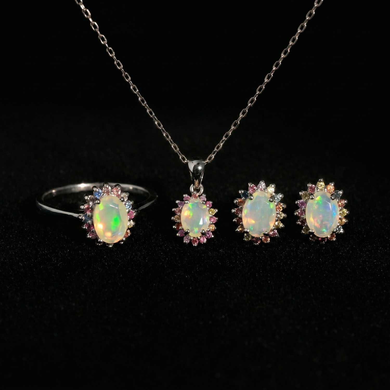 orijinal-opal-ve-renkli-safir-dogal-tas-gumus-set Juego de joyas de lujo en plata de ley 925 que incluye anillo, pendientes y colgante adornados con ópalos cabujón y zafiros de colores.