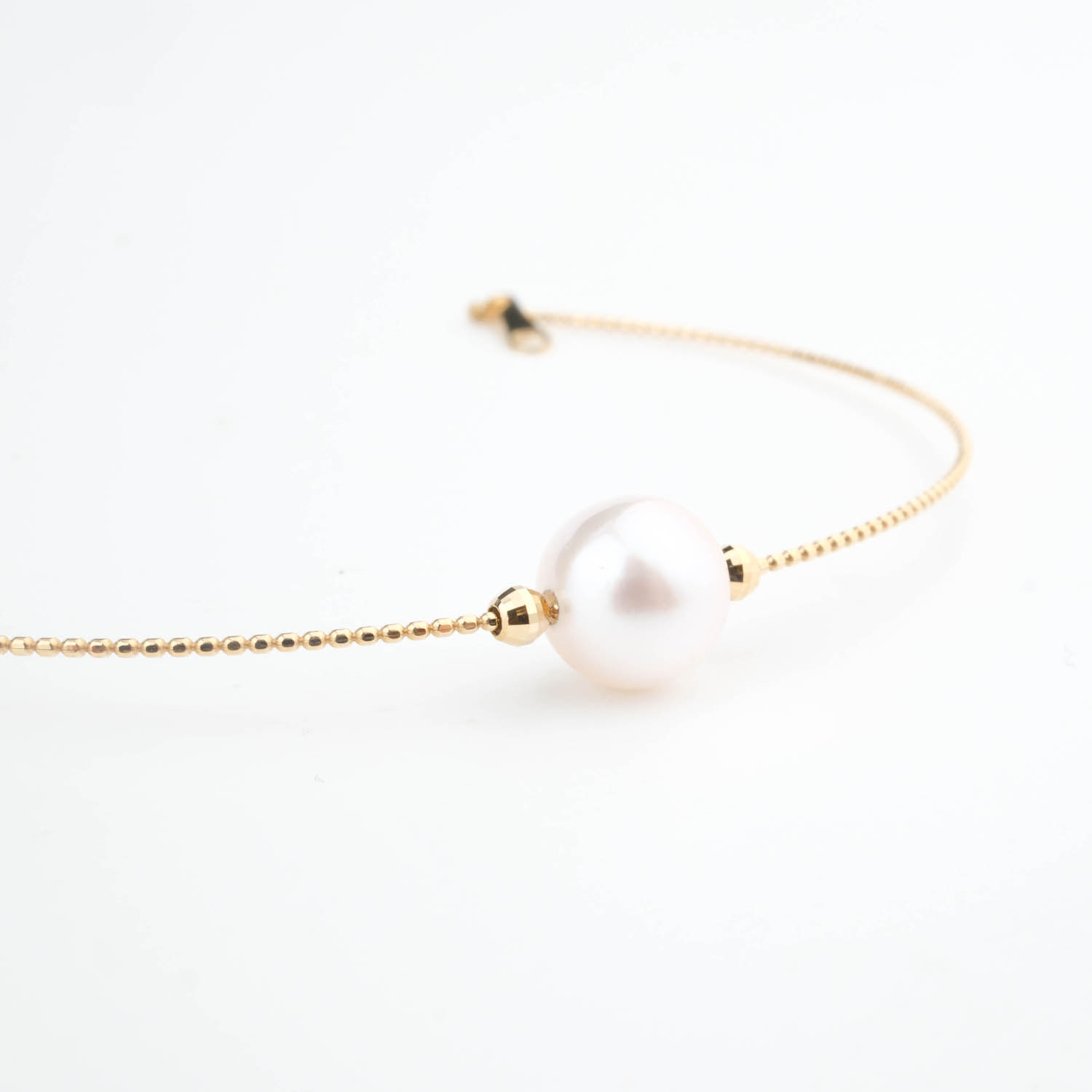 pulsera-oro-perla-diseno Zartes 18-karätiges Goldkettenarmband mit einer originalen weißen Perle in der Mitte.