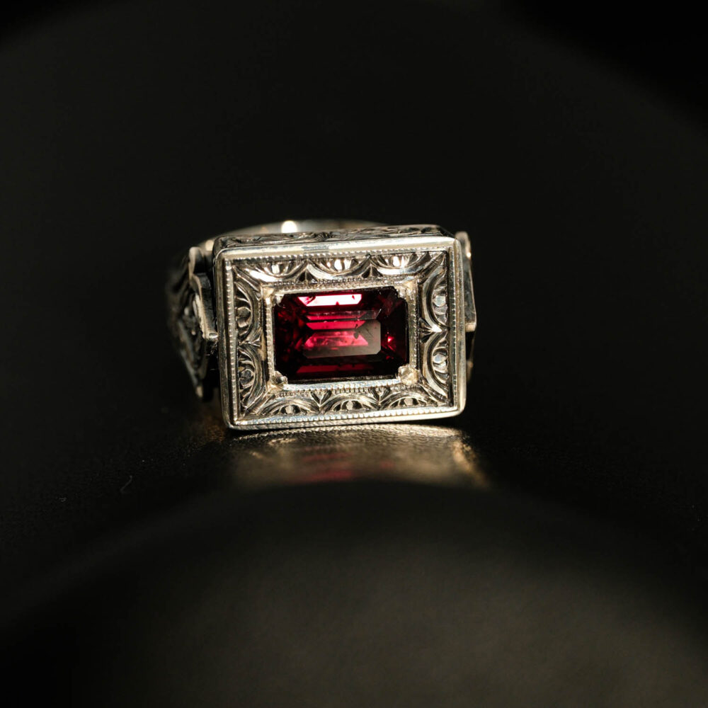 Anillo de hombre de plata 925 con una piedra natural de granate original de talla faceta rectangular en un marco cuadrado con motivos florales hechos a mano.