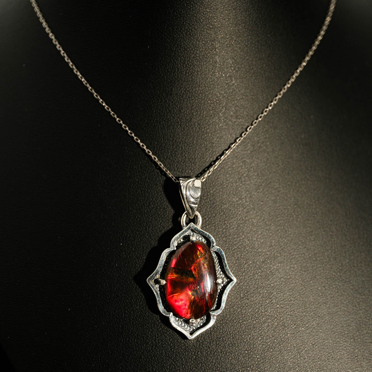 قلادة-فضة-صنع-يدوي-أوبال-أمونيت-بودريال Halskette aus 925er Sterlingsilber mit einem originalen Ammonit-Bodrial-Opal-Naturstein mit roten und grünen feurigen Reflexen und detaillierten handgefertigten Motiven.