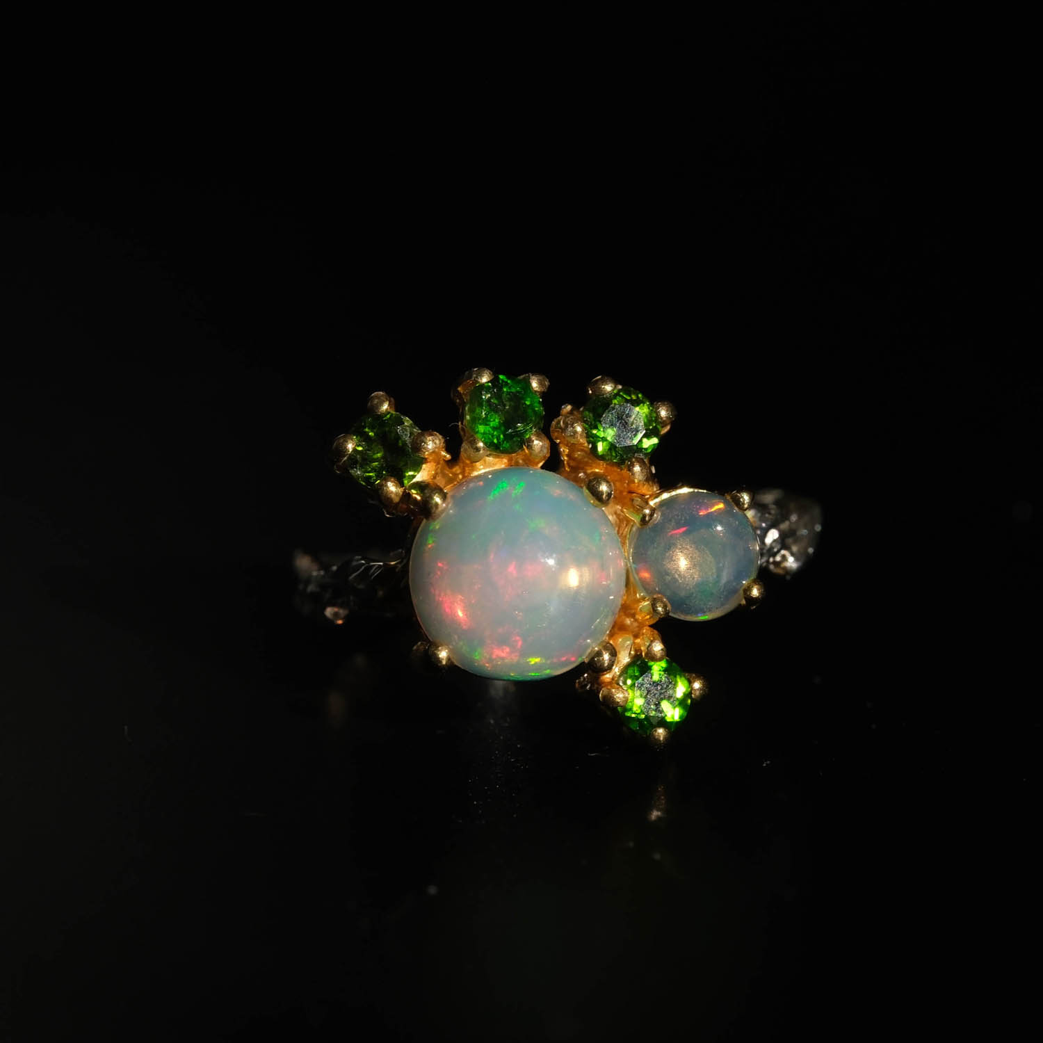 anillo-diseno-lujo-piedra-opalo-y-tsavorita-natural-plata-925 Anillo de diseño de lujo en plata de ley 925 con detalles en oro, adornado con una gema de ópalo natural y tsavoritas de corte faceteado.