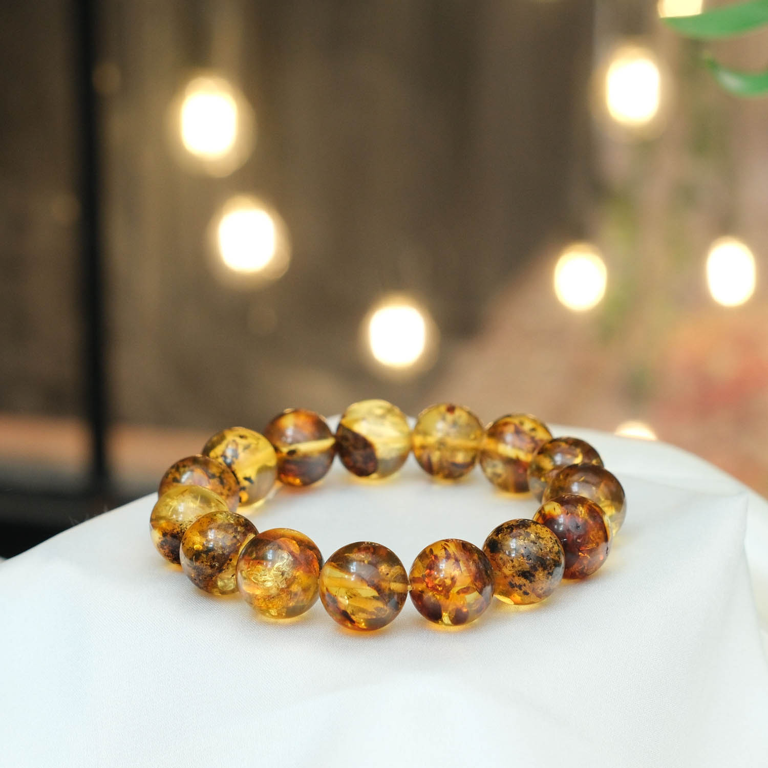 bracciale-ambra-baltica-naturale-originale-adulto-sfere 13-14mm dolgun küre kesim bal ve konyak tonlarında yarı saydam orijinal yetişkin Baltık kehribarı doğal taş tasarım bileklik modeli.
