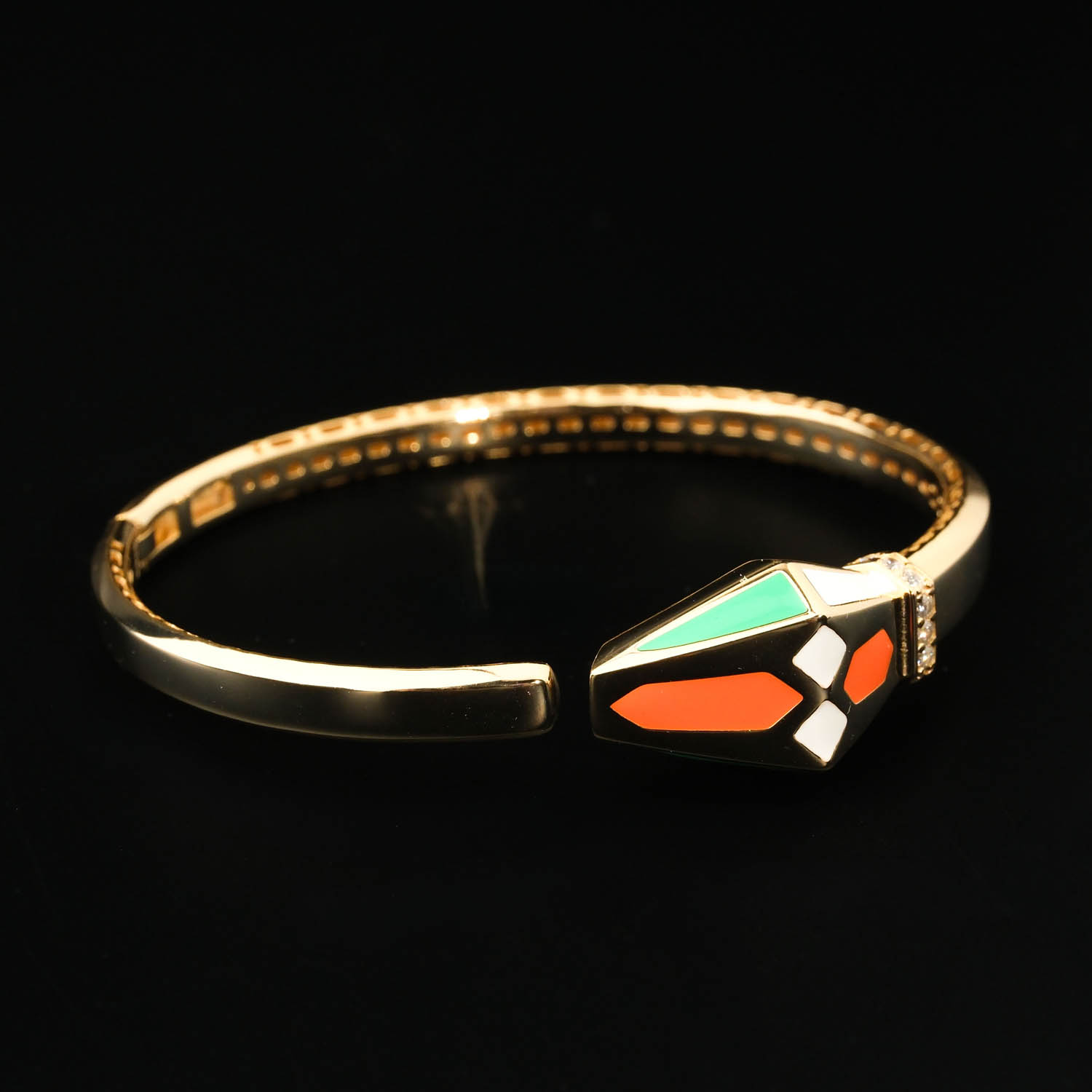 bracciale-rigido-argento-925-placcato-oro-smalto-lusso Bracelet manchette de luxe en argent sterling 925 plaqué or orné de détails en émail géométrique et de zircons.