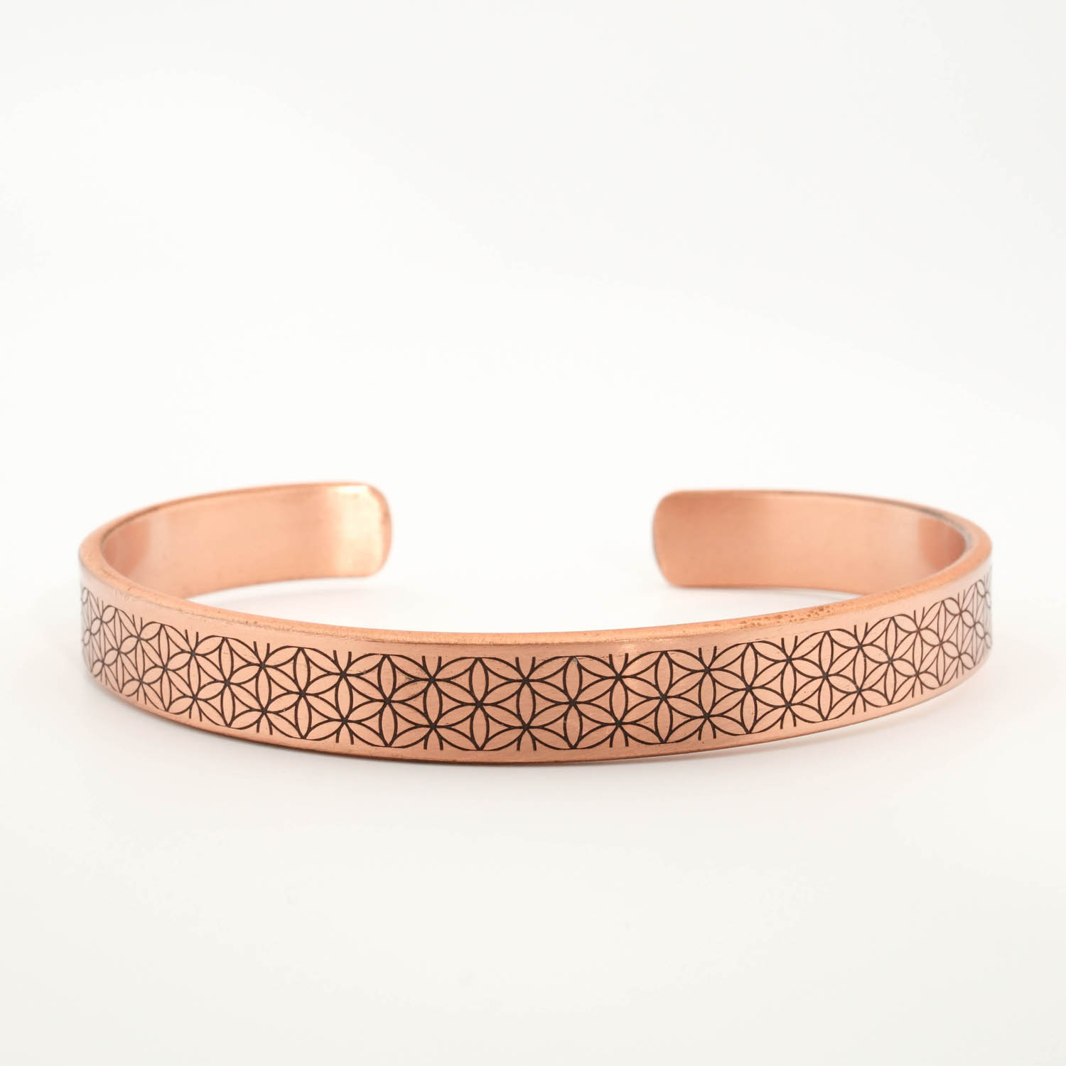 bracelet-luxe-femme-homme-cuivre-pur-fleur-de-vie-ayat-al-kursi A luxury handcrafted pure copper cuff bracelet featuring an engraved flower of life pattern on the outside and Ayat al-Kursi inside.