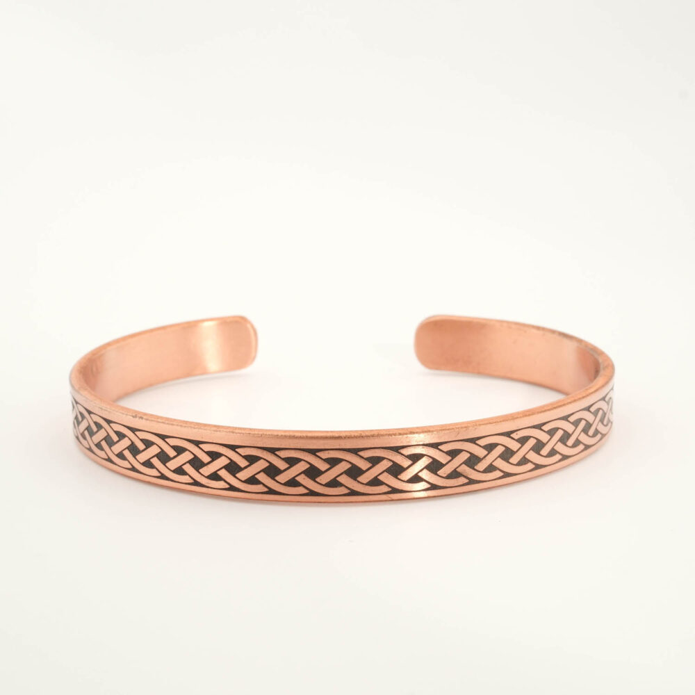 A luxury handcrafted pure copper cuff bracelet featuring an engraved braided pattern on the outside and Ayat al-Kursi inside.