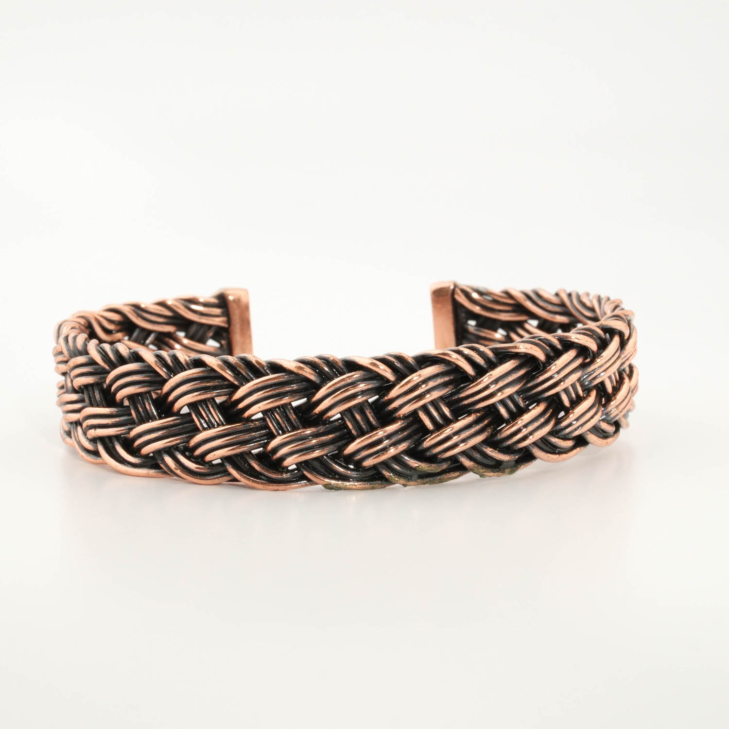 bracelet-tresse-epais-homme-femme-cuivre-pur-artisanala Bracciale rigido e spesso in rame puro intrecciato a mano con finitura brunita stile vintage.