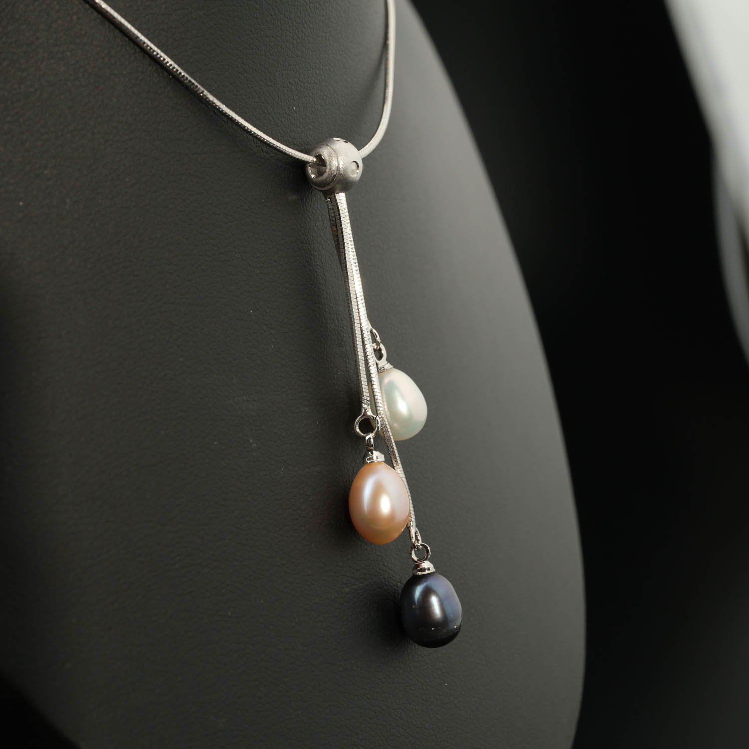 colgante-perla-tricolor-de-oceano-piedra-natural-acero-43cm Ciondolo di design di lusso in acciaio inossidabile con tre perle naturali dell'oceano tricolori a forma di goccia.