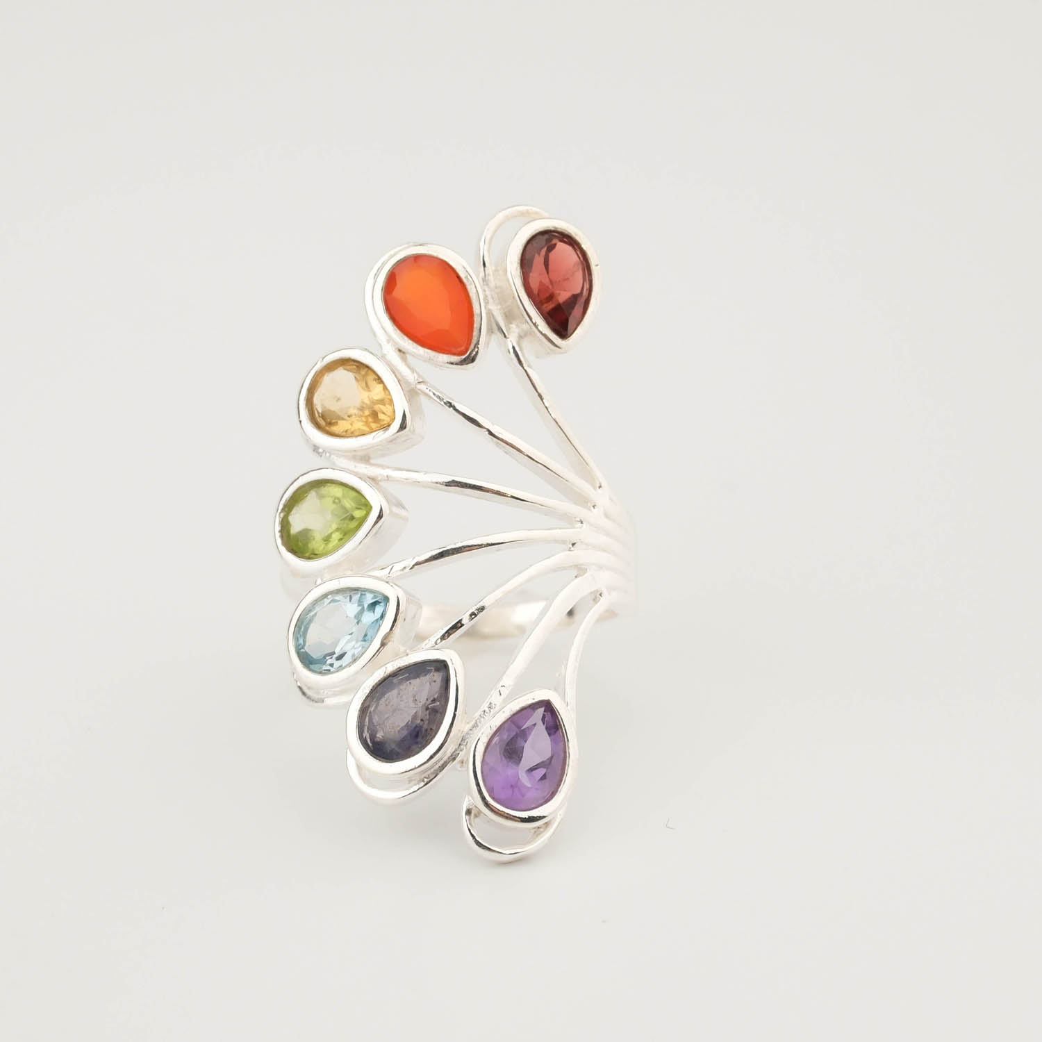 خاتم-متعدد-الأحجار-الكريمة-الطبيعية-شاكرات-فضة-925-فاخر A luxury multi-gemstone statement ring featuring seven natural chakra stones set in a 925 sterling silver fan design.