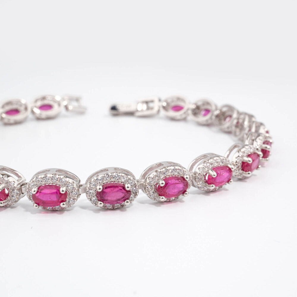 Bracelet de haute joaillerie en argent 925 rhodié avec rubis naturels ovales et halo de zircons étincelants.