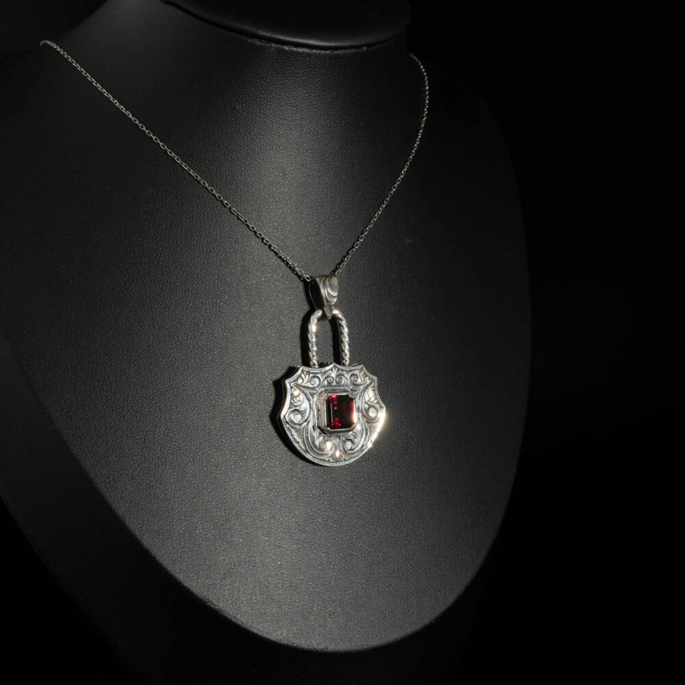 An authentic natural baguette cut red garnet gemstone padlock design engraved 925 sterling silver pendant necklace.