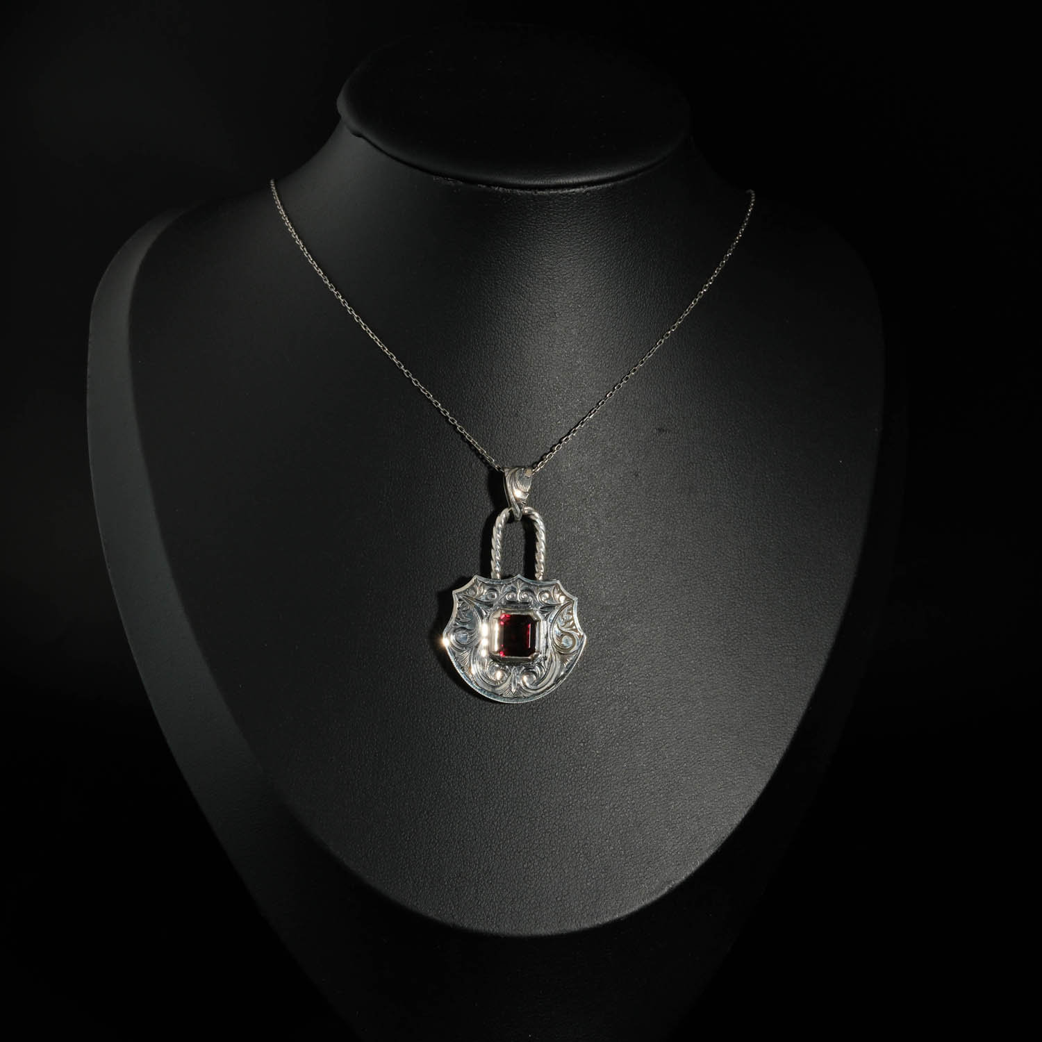 pendentif-femme-argent-925-cadenas-grenat-naturel-taille-baguette Pendentif artisanal en argent 925 oxydé en forme de cadenas avec grenat rouge naturel taille baguette et gravures faites main.