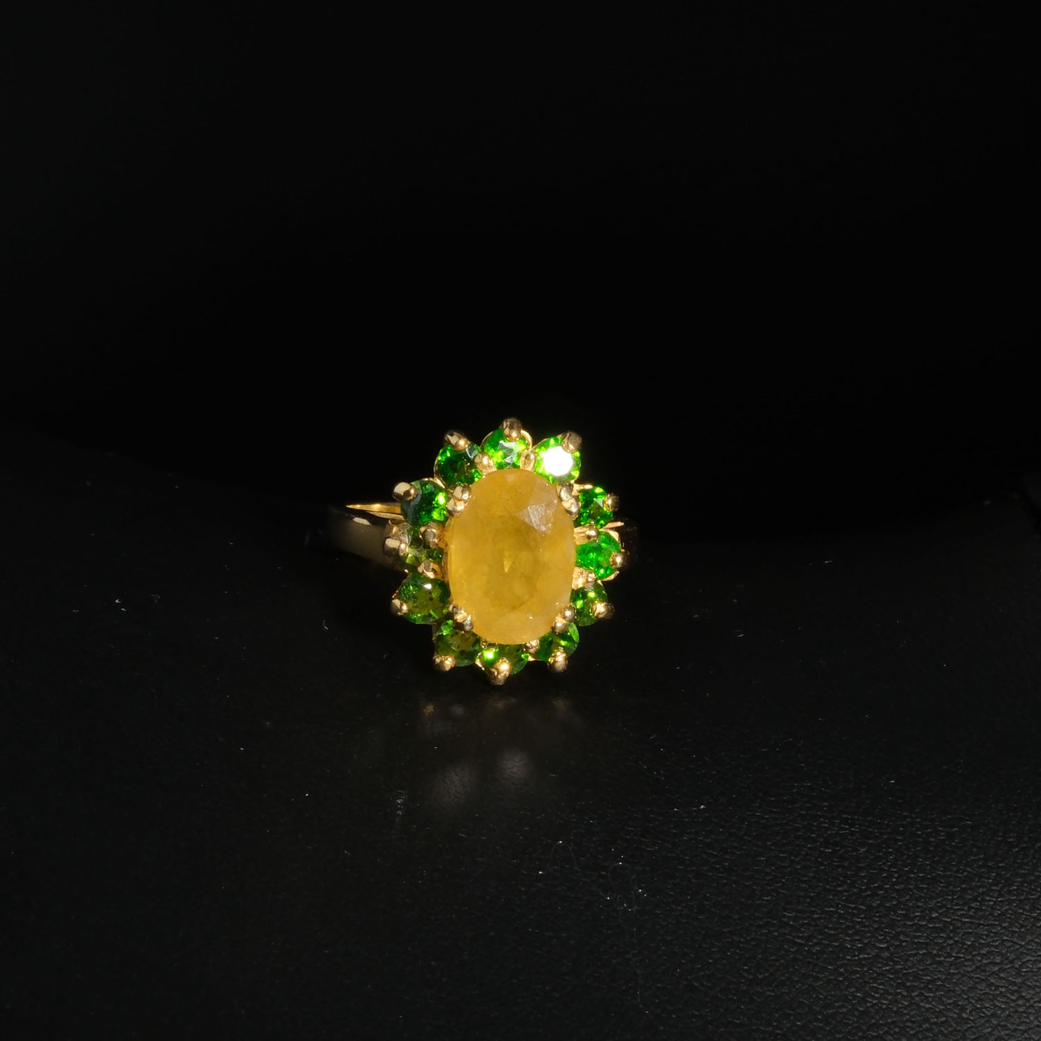 bague-femme-argent-925-plaque-or-saphir-jaune-tsavorite-naturelle-rosette Bague florale d'exception en argent 925 plaqué or ornée d'un saphir jaune naturel facetté et de grenats tsavorites sur fond blanc.