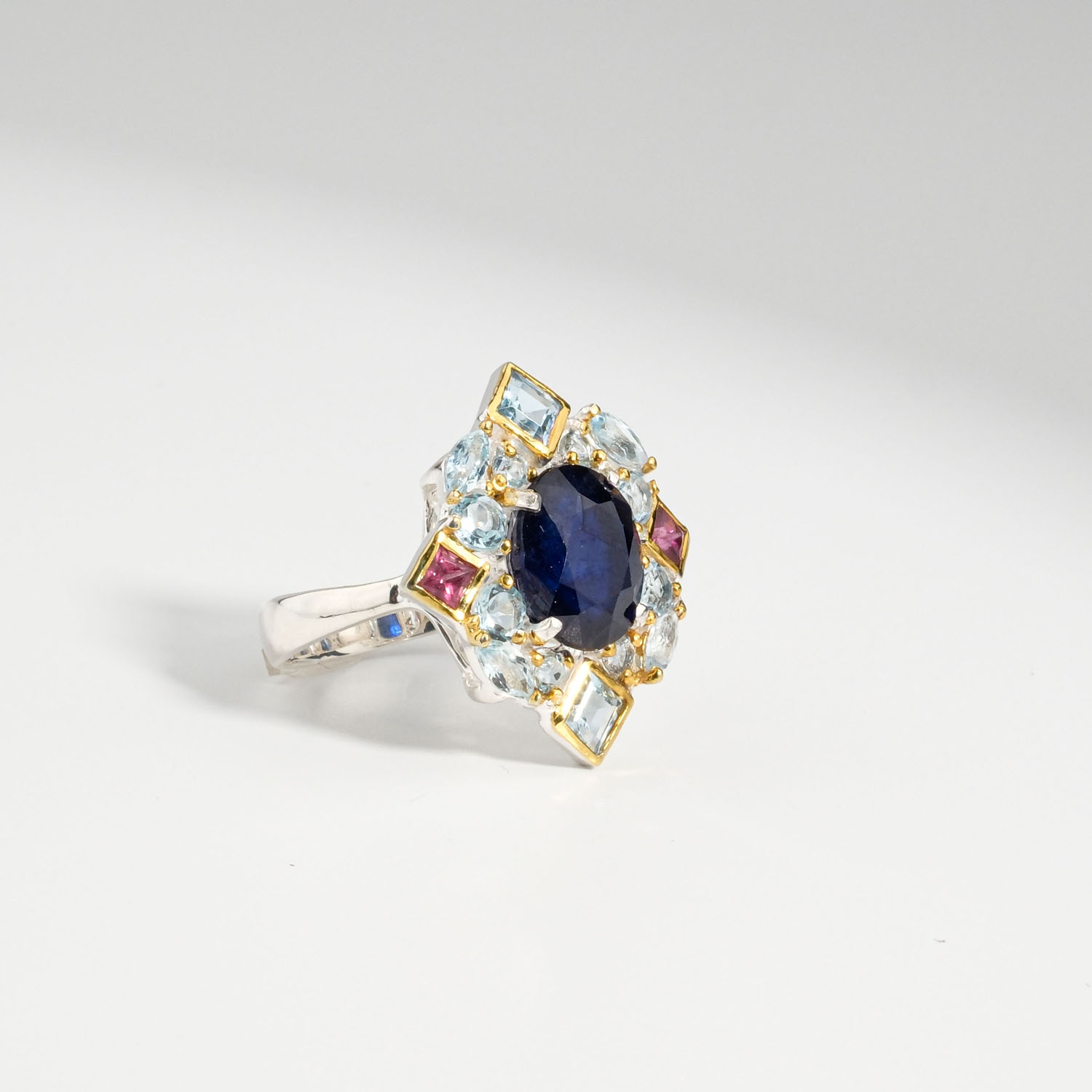 damen-ring-925-silber-blauer-saphir-topas-turmalin-halo.jpg Damen Ring aus 925 Silber mit ovalem blauem Saphir, blauem Topas und rosa Turmalin auf weißer Seide.
