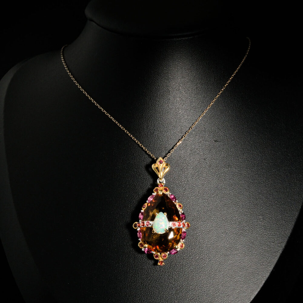 Pendentif de prestige en argent 925 orné d'une citrine goutte facettée, opale iridescente et tourmaline rubellite sur fond noir.